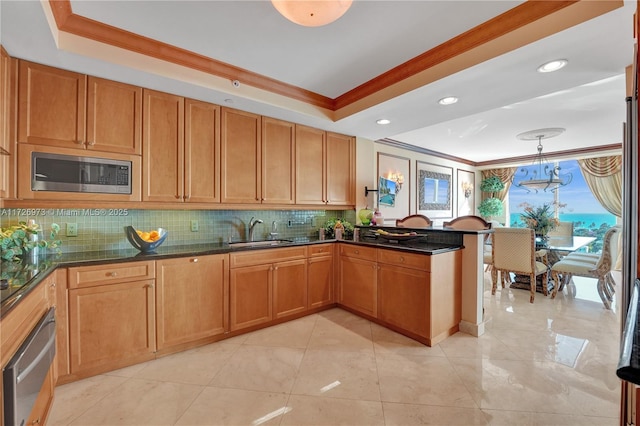 kitchen featuring stainless steel microwave, crown molding, pendant lighting, and sink