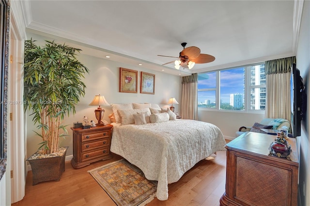 bedroom featuring ceiling fan, light hardwood / wood-style flooring, and crown molding