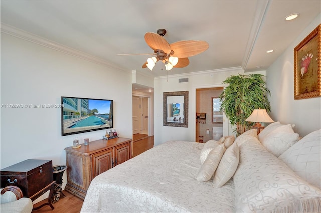 bedroom with ceiling fan, hardwood / wood-style floors, and crown molding