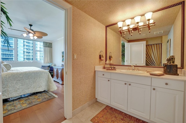 bathroom featuring ceiling fan, ornamental molding, hardwood / wood-style flooring, and vanity