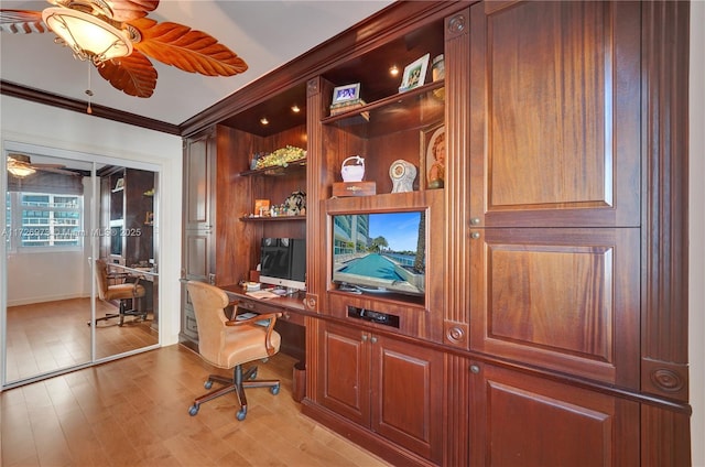 office with ceiling fan, ornamental molding, built in desk, and light hardwood / wood-style floors