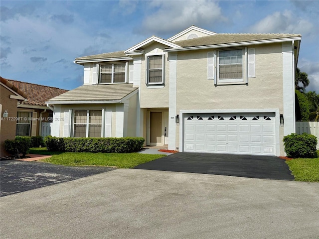 traditional-style house with stucco siding, an attached garage, driveway, and a tile roof