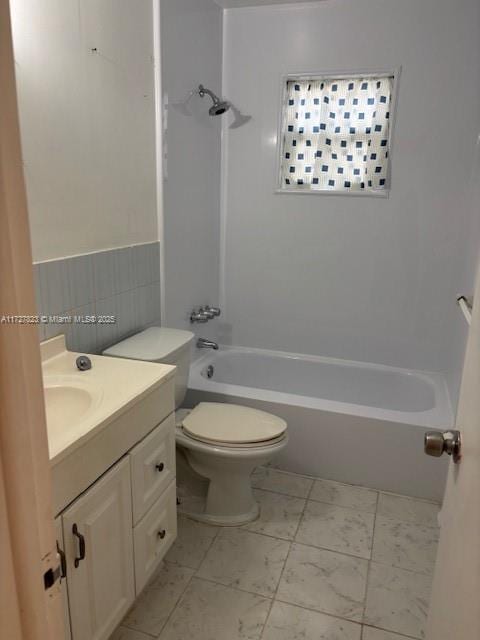 full bathroom featuring toilet, vanity, tile walls, and shower / washtub combination