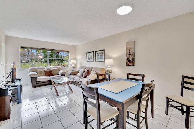 dining space with light tile patterned floors and a textured ceiling