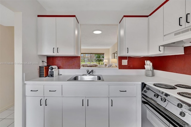 kitchen featuring white electric range oven, light tile patterned flooring, white cabinets, and sink