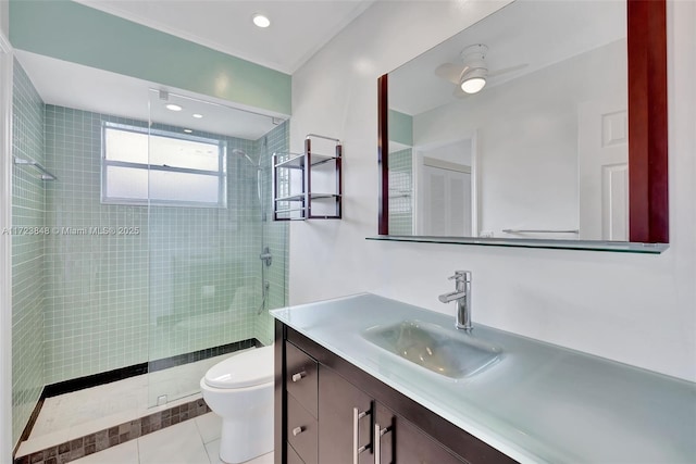 bathroom with tile patterned flooring, vanity, ceiling fan, toilet, and a shower with shower door