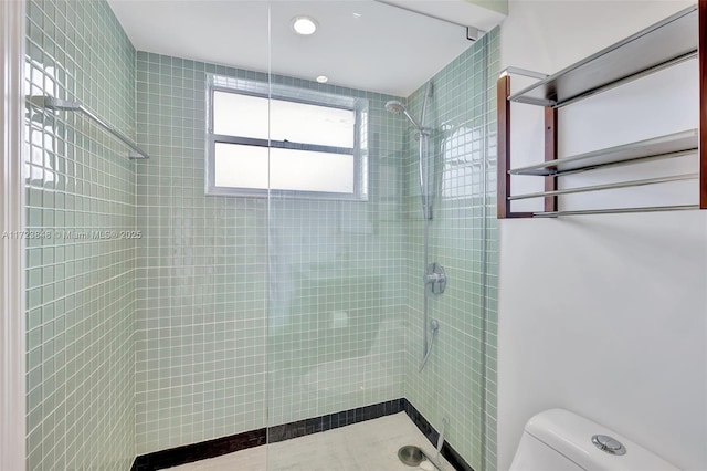 bathroom with toilet and a tile shower