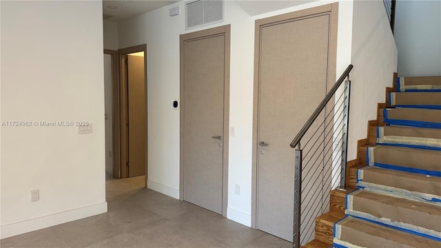 stairs featuring concrete flooring