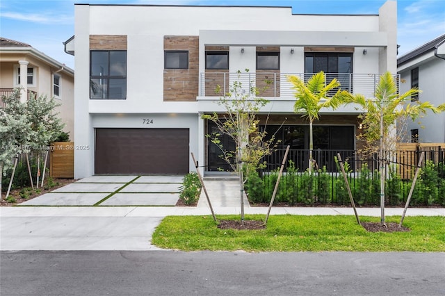 contemporary house featuring stucco siding, fence, driveway, and a garage