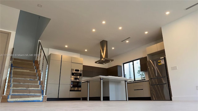 kitchen with appliances with stainless steel finishes, island exhaust hood, and gray cabinets