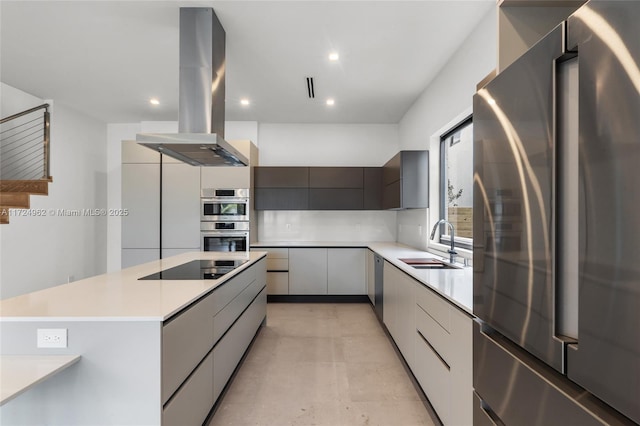 kitchen with stainless steel appliances, a sink, island range hood, modern cabinets, and light countertops