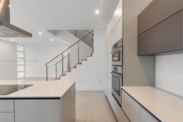kitchen with wall chimney exhaust hood, recessed lighting, stainless steel double oven, black electric stovetop, and light countertops