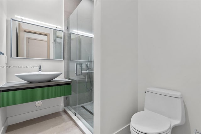 full bathroom featuring vanity, a shower stall, and toilet