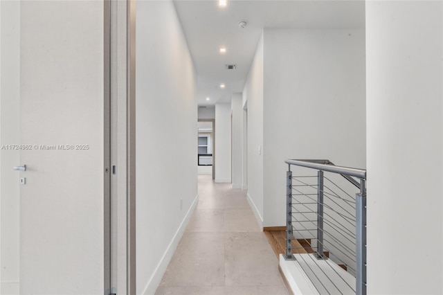 hallway featuring recessed lighting, visible vents, an upstairs landing, concrete flooring, and baseboards