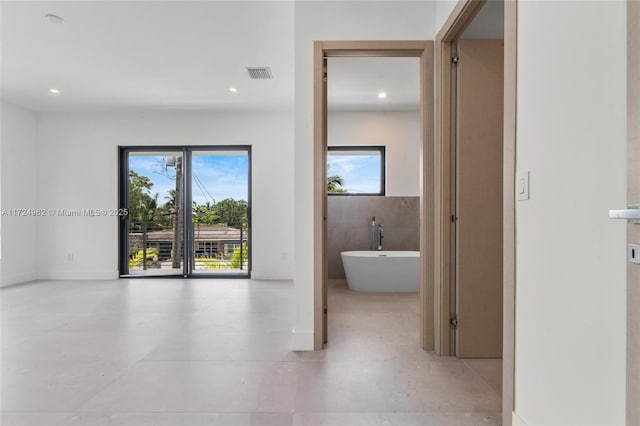 hallway featuring visible vents and recessed lighting