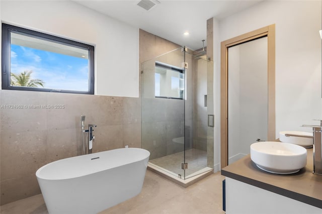 bathroom featuring a shower stall, double vanity, visible vents, concrete floors, and a soaking tub