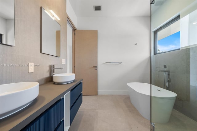 bathroom with a sink, double vanity, a freestanding bath, visible vents, and concrete floors