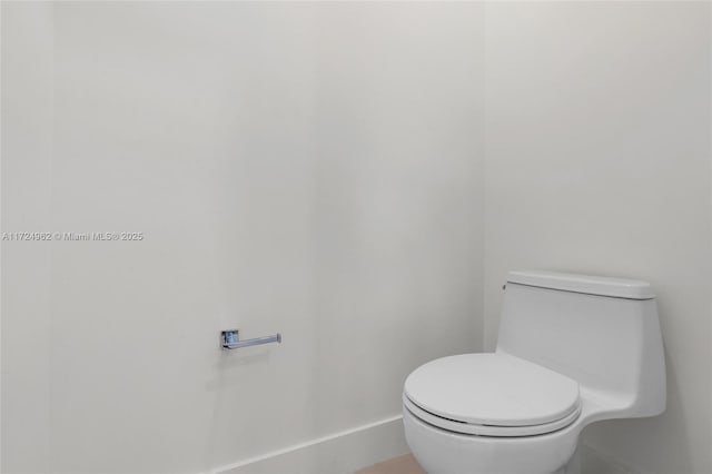 bathroom featuring toilet and baseboards