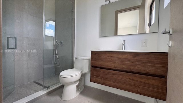 bathroom featuring toilet, a shower with door, and vanity