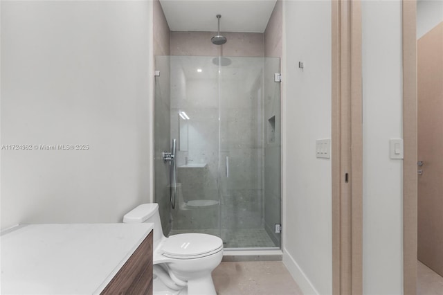 bathroom featuring baseboards, vanity, toilet, and a stall shower