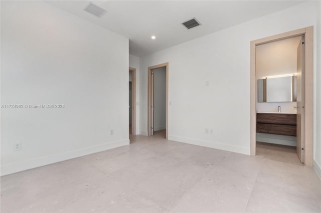 unfurnished bedroom featuring concrete flooring, visible vents, baseboards, and connected bathroom