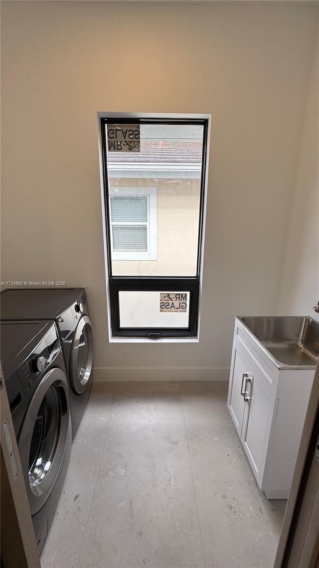 laundry room featuring cabinets, sink, and independent washer and dryer