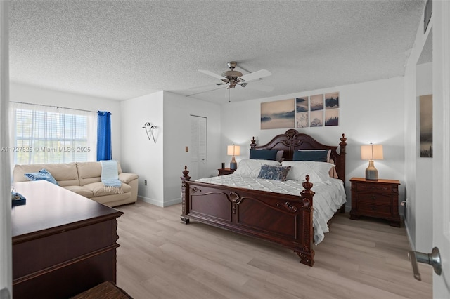 bedroom featuring ceiling fan, a textured ceiling, a closet, and light hardwood / wood-style flooring