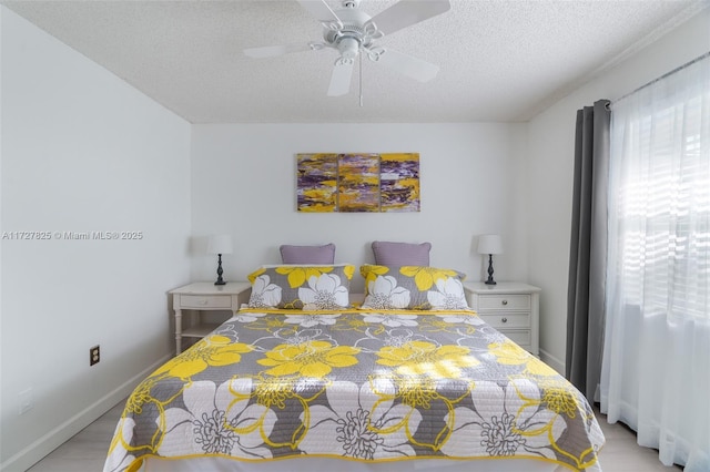 bedroom featuring ceiling fan, light hardwood / wood-style floors, and a textured ceiling