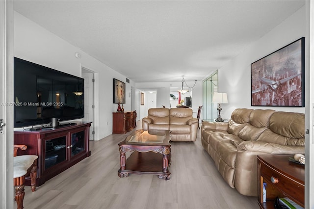 living room with a textured ceiling and light wood-type flooring