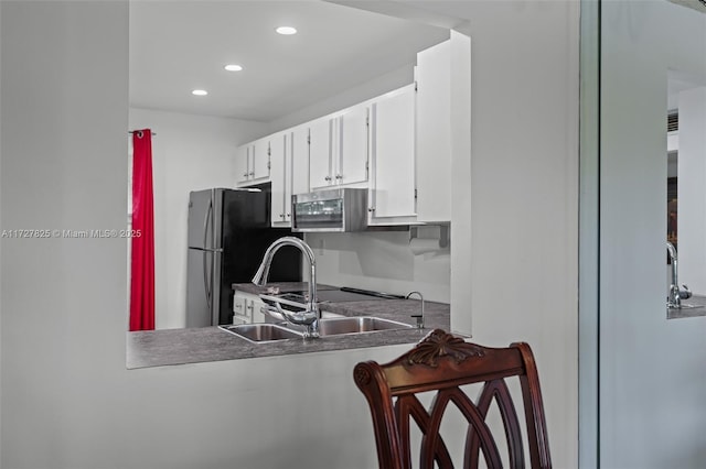 kitchen with white cabinetry, stainless steel appliances, and sink