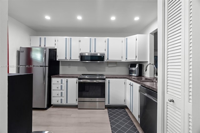 kitchen featuring appliances with stainless steel finishes, white cabinets, and sink