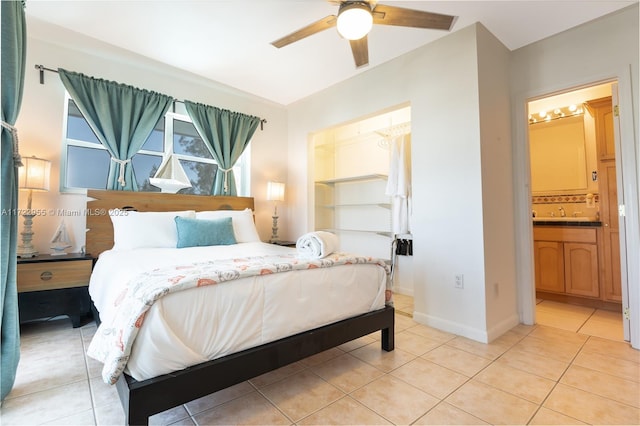 bedroom with light tile patterned floors, ceiling fan, and ensuite bathroom