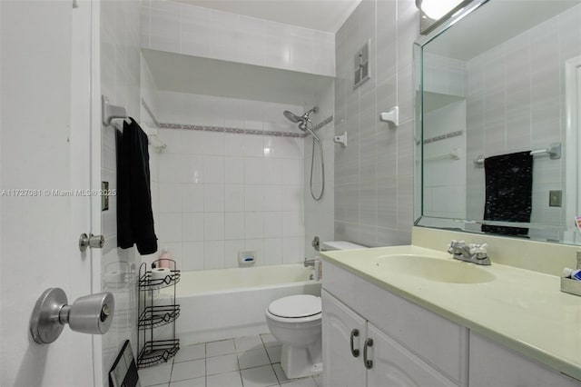 full bathroom featuring toilet, tiled shower / bath, tile walls, tile patterned floors, and vanity