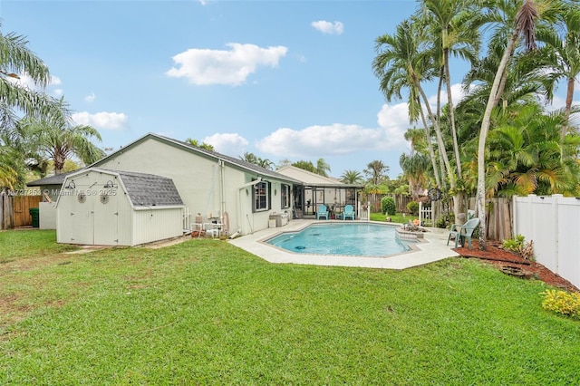 back of house with a fenced in pool, a yard, and a storage unit