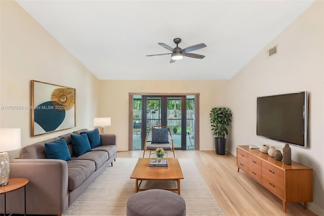 living room with light wood-type flooring, ceiling fan, french doors, and lofted ceiling