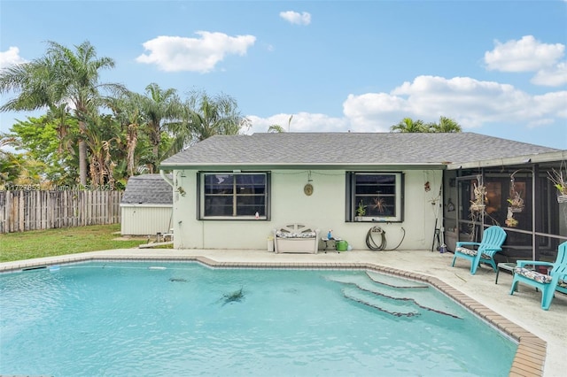 view of swimming pool with a patio and a storage unit