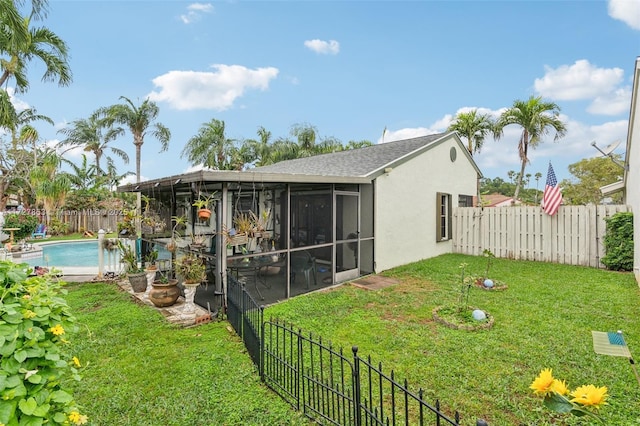 back of property featuring a fenced in pool, a yard, and a sunroom