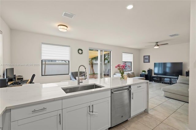 kitchen featuring white cabinets, dishwasher, sink, ceiling fan, and light tile patterned floors