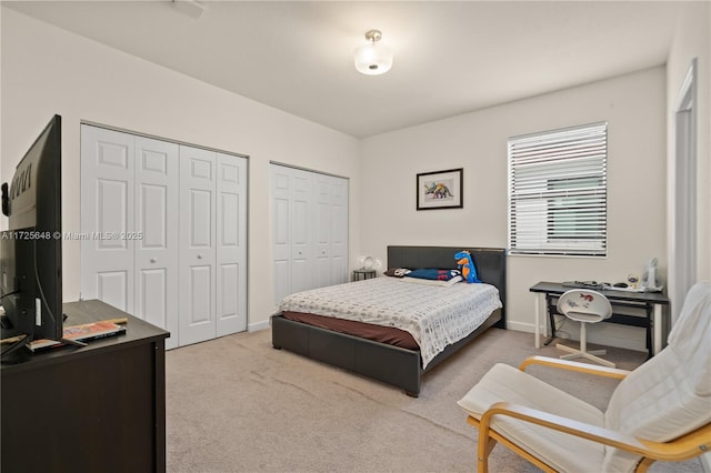 bedroom featuring multiple closets and light colored carpet