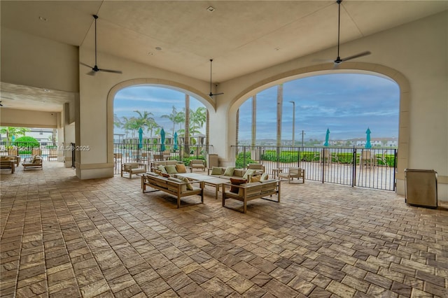 view of patio featuring ceiling fan, an outdoor living space, and a water view