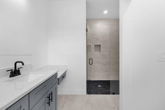 bathroom with a shower with shower door and vanity