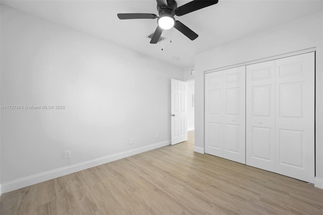 unfurnished bedroom featuring ceiling fan, a closet, and light hardwood / wood-style flooring