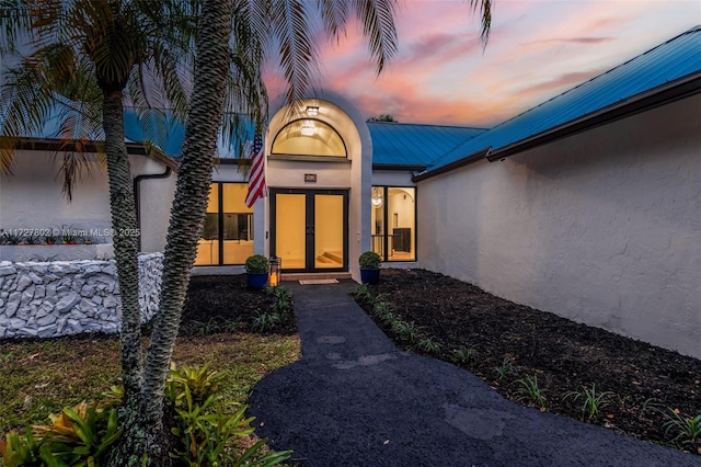 exterior entry at dusk featuring french doors