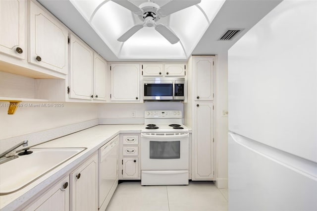 kitchen with light tile patterned floors, visible vents, ceiling fan, a sink, and white appliances