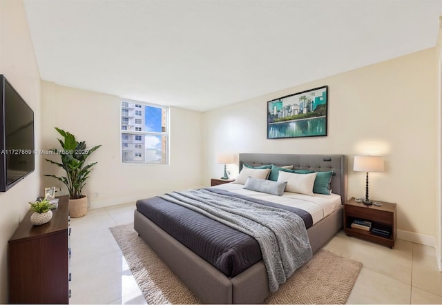 bedroom with light tile patterned floors and baseboards