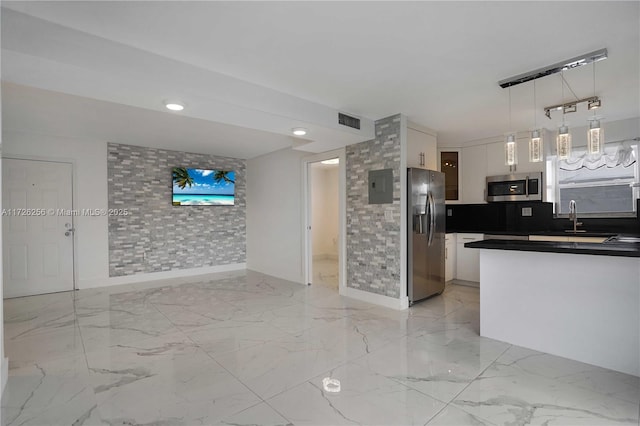 kitchen with white cabinets, stainless steel appliances, sink, hanging light fixtures, and electric panel