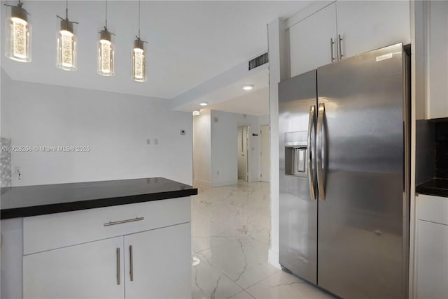 kitchen with stainless steel fridge with ice dispenser, white cabinetry, and hanging light fixtures