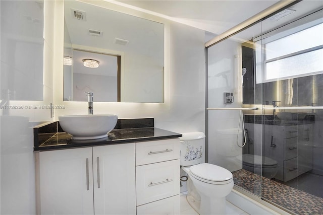 bathroom with toilet, vanity, an enclosed shower, and tile patterned flooring