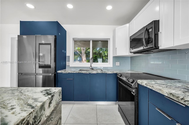 kitchen with white cabinets, appliances with stainless steel finishes, sink, light stone counters, and blue cabinets