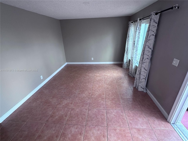 tiled empty room with a textured ceiling